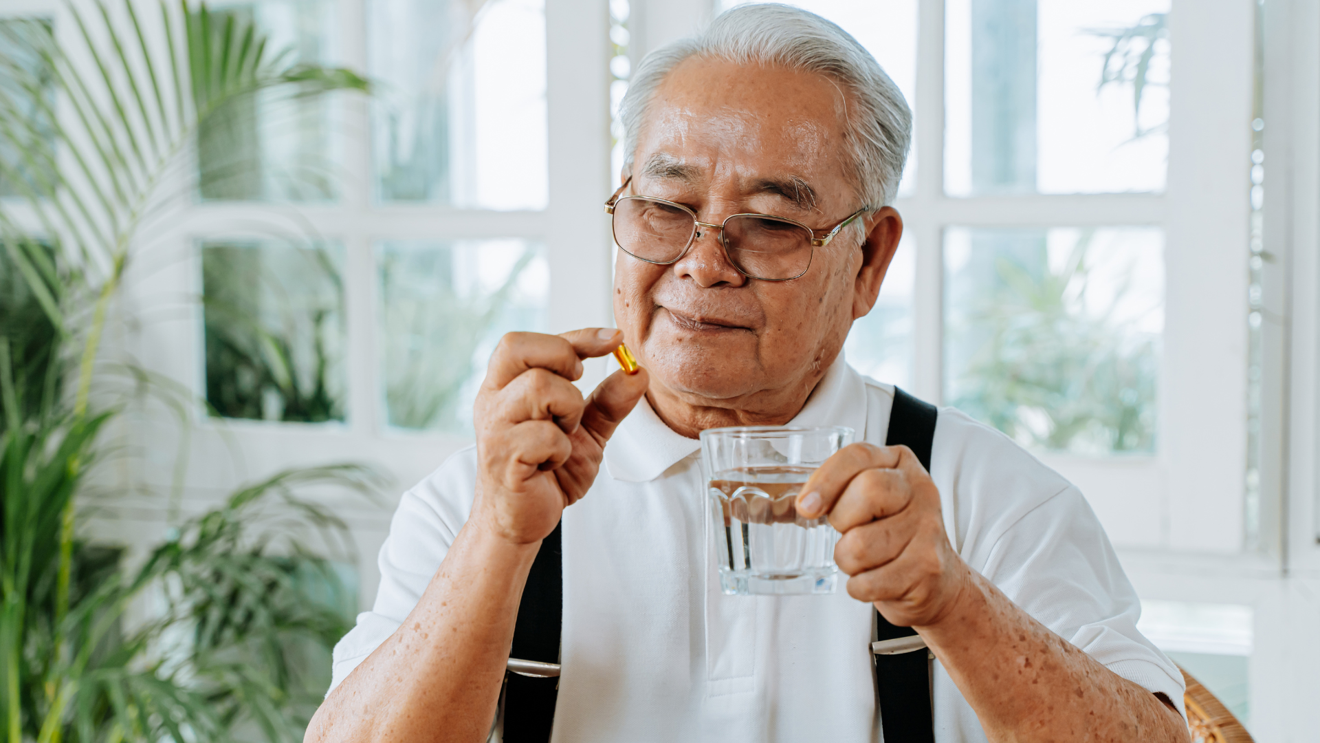 Care home resident confidently removes his pill from medication packaging and gets ready to take it